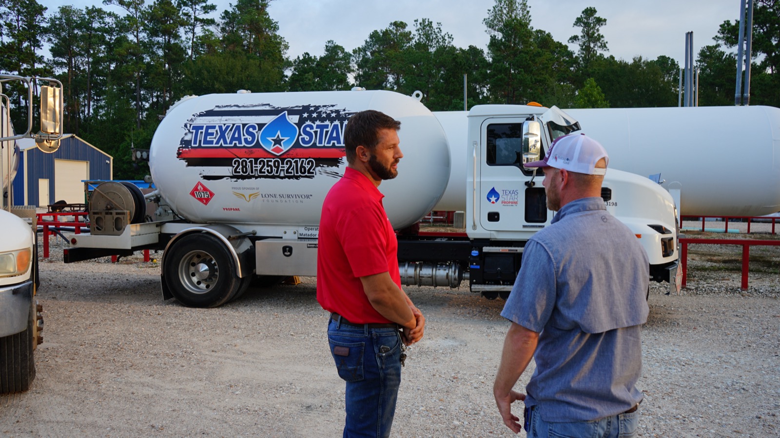 Two Texas Star Propane staff talking in front of a branded tanker before a run