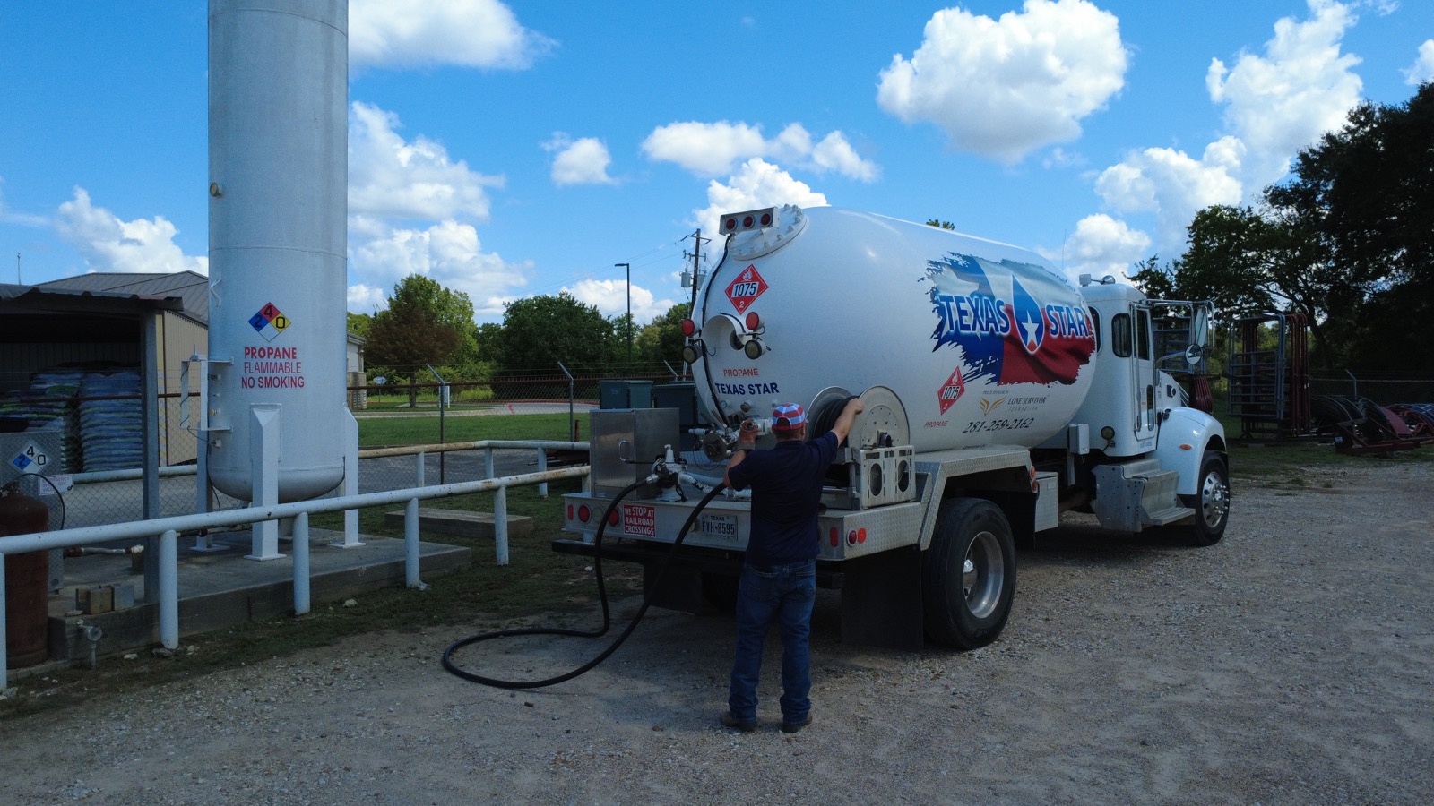 A driver filling a bulk storage tank from a Texas Star Propane truck.