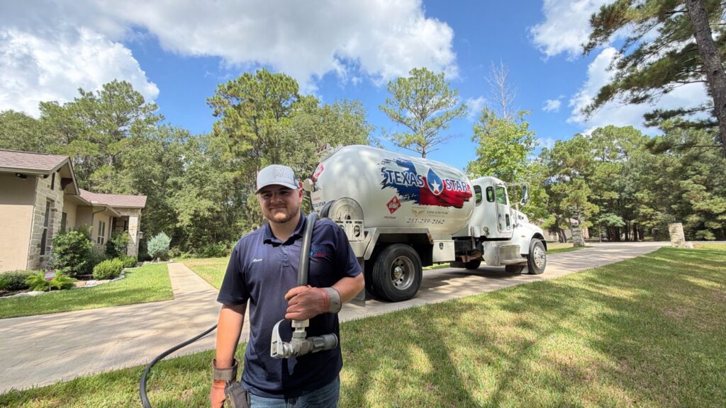 A branded Texas Star truck with a driver and hose in a residential setting.