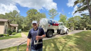 A branded Texas Star truck with a driver and hose in a residential setting.