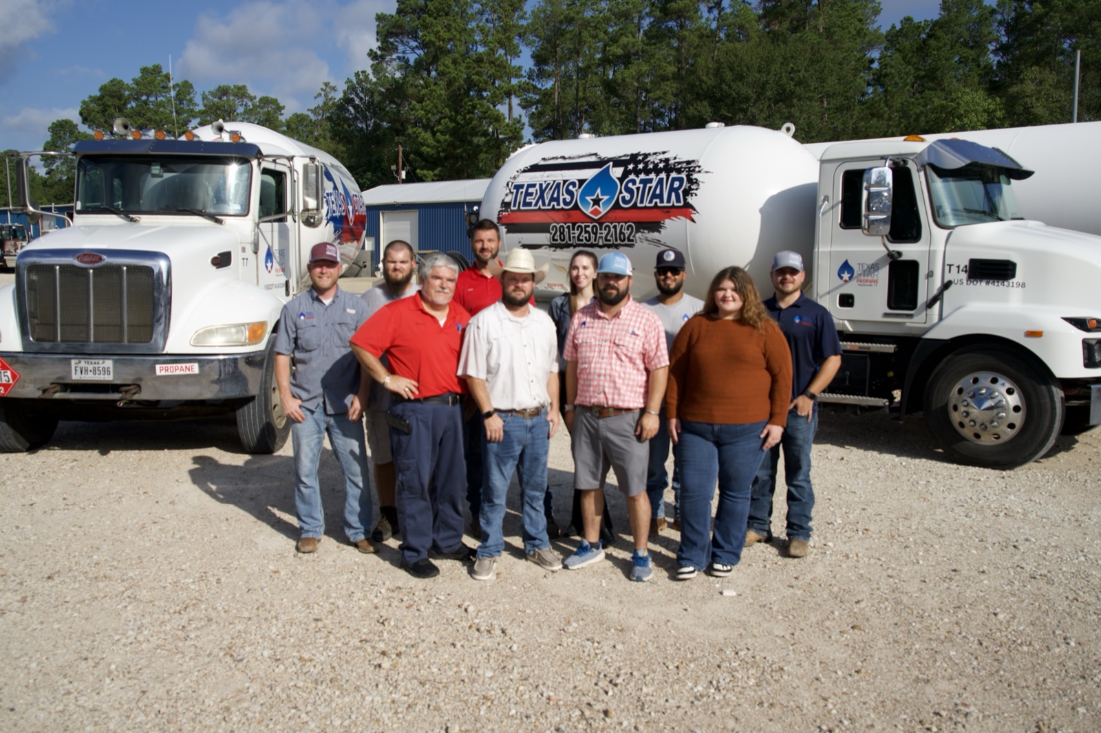 The Texas Star Propane team standing together at the Plantersville yard in front of two branded delivery trucks.