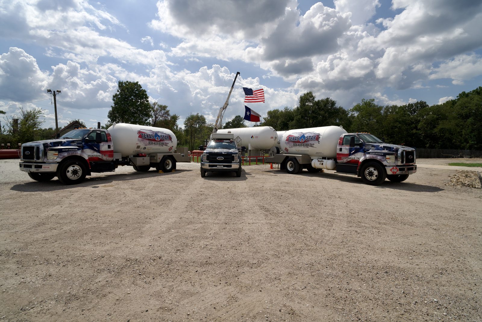 Bryan, TX two propane delivery trucks and a service vehicle in a gravel lot