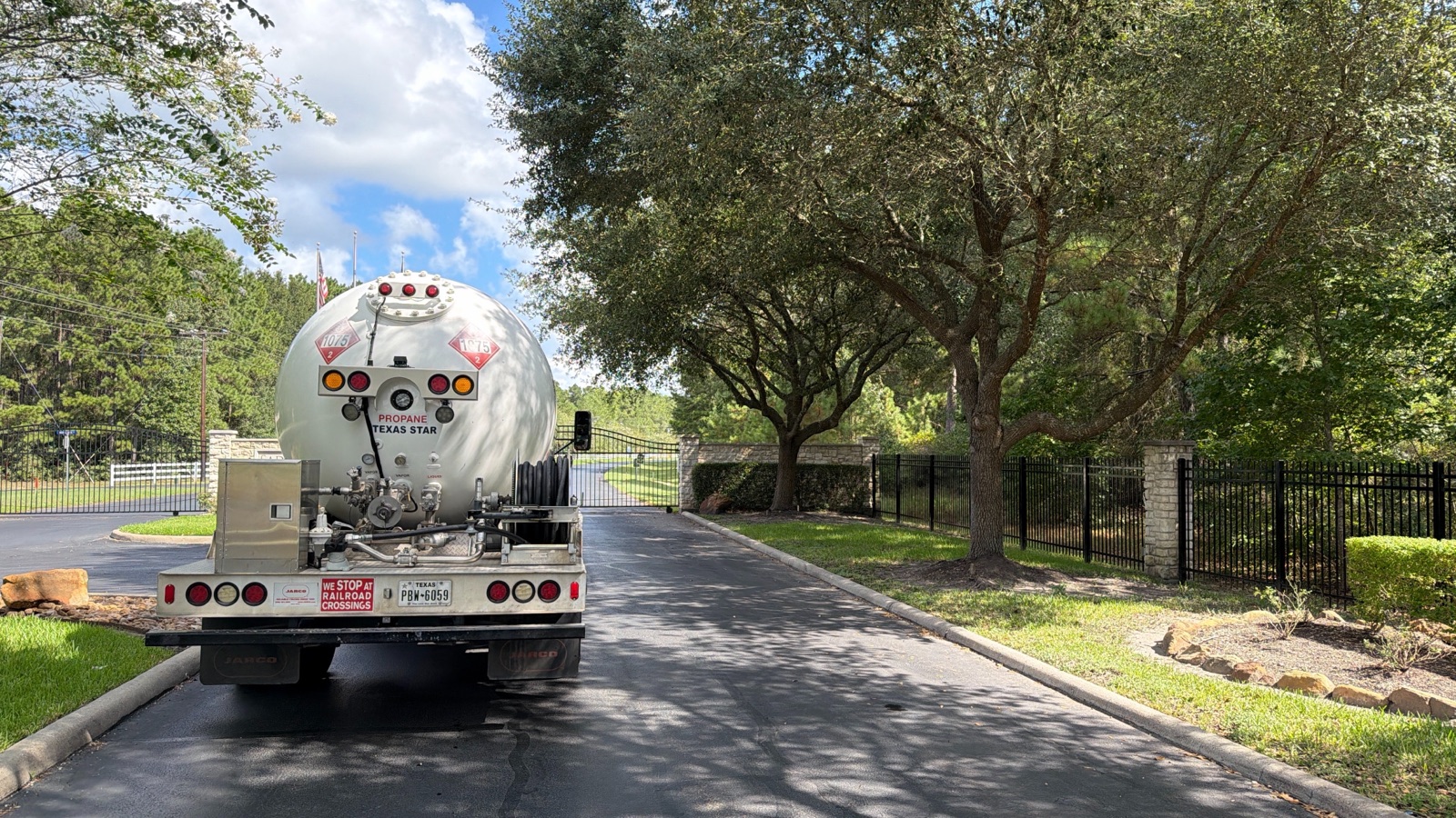 A propane delivery truck entering a residential community.