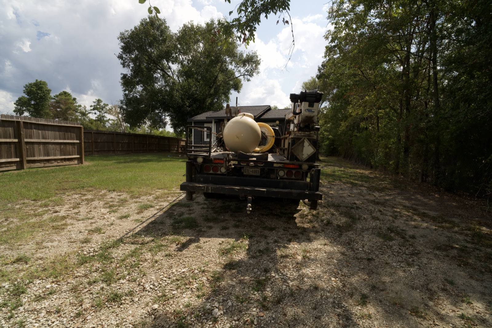A Texas Star propane delivery truck parked at a tank set in a wooded lot.